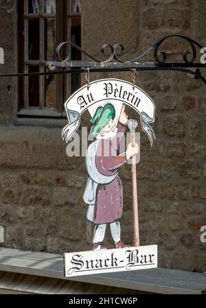 Le Mont Saint Michel, Francia - 13 Settembre 2018: artisticamente stilizzata pubblicità dei negozi e ristoranti sul Grand Rue, la strada principale di Mon Foto Stock