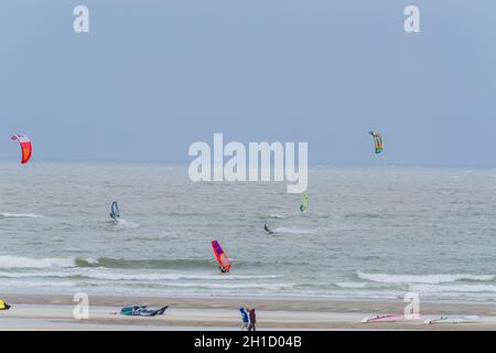 BROUWERSDAM, ZEELAND, PAESI BASSI - 13 GIUGNO 2015: Brouwersdam, kitesurfers del Mare del Nord, windsurfers in mare tempestoso sulla spiaggia. Vento forte da sabbia dr Foto Stock