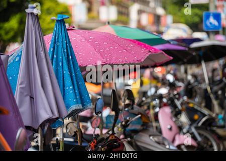 Yangshuo, Cina - Agosto 2019 : fila di piccole moto e scooter parcheggiati su una strada nella città di Yangshuo, provincia di Guangxi Foto Stock
