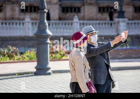 SIVIGLIA, SPAGNA - 7 marzo: Coppia non identificata con l'uomo che indossa la maschera per proteggere se stesso e gli altri da coronavirus prendere selfie. 7 marzo 2020 a Sevi Foto Stock