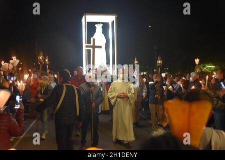 Lourdes, Francia - 9 Ott 2021: Una statua della Vergine Maria viene trasportata tra le folle durante la Processione Mariana Torchlight nella Basilica del Rosario i Foto Stock