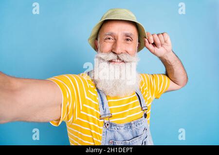 Foto di vecchio uomo allegro felice sorriso positivo rendere selfie viaggio estivo isolato su sfondo blu Foto Stock