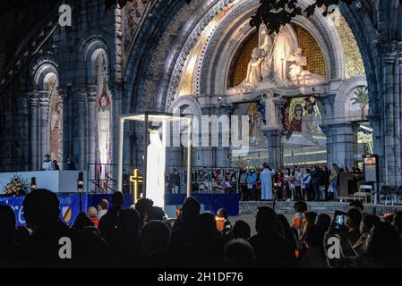 Lourdes, Francia - 9 Ott 2021: Una statua della Vergine Maria viene trasportata tra le folle durante la Processione Mariana Torchlight nella Basilica del Rosario i Foto Stock