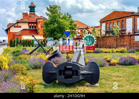 Stettin Polonia, Giugno 2018 Anchori e attrezzature nautiche, decorazione floreale per il 70 ° anniversario del cantiere navale di Szczecin, edifici portuali in background Foto Stock