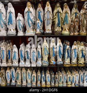 Lourdes, Francia - 9 Ott 2021: Statue figurine della Vergine Maria in vendita presso un negozio di souvenir turistico a Lourdes, Francia Foto Stock