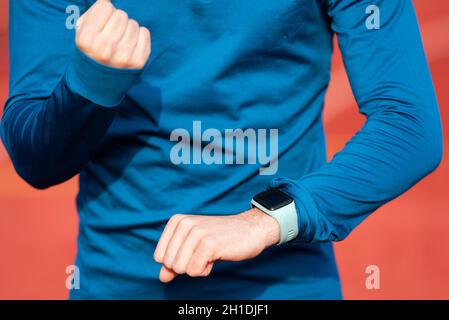 Runner con successo guardando il monitor per la Frequenza Cardiaca Smart Watch, close up . Foto Stock