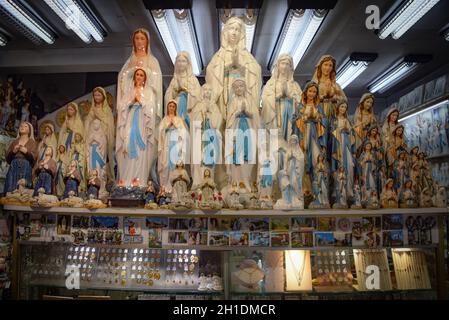 Lourdes, Francia - 9 Ott 2021: Statue figurine della Vergine Maria in vendita presso un negozio di souvenir turistico a Lourdes, Francia Foto Stock