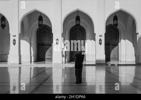 Salalah, Oman - 12 Novembre 2017: turistici nel cortile del Sultano Qaboos moschea in Salalah, Sultanato di Oman. La fotografia in bianco e nero. Foto Stock