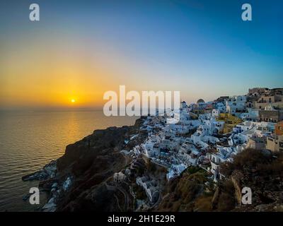 Vista panoramica del villaggio di Oia con la tradizionale architettura bianca e mulini a vento nell'isola di Santorini nel mare Egeo al tramonto, sfondo del viaggio, Santor Foto Stock