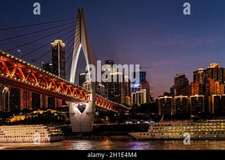 Chongqing, Cina - Agosto 2019 : illuminato DongShuiMen ponte strada sopra e attraverso il possente fiume Yangtze nella città di Chongqing al crepuscolo Foto Stock