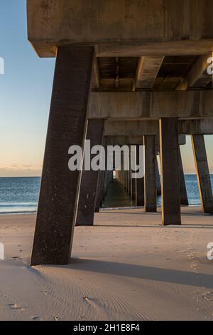 La sottostruttura del molo di pesca del Gulf state Park all'alba crea modelli interessanti sulla spiaggia di Gulf Shores, Alabama Foto Stock