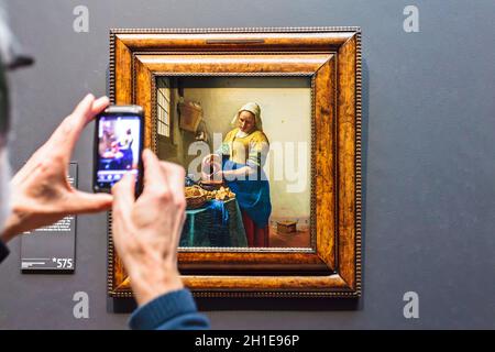 AMSTERDAM, PAESI BASSI - 12 MARZO 2015: Il turista scatta una foto del telefono delle cellule della pittura dell'olio della Milkmaid da Johannes Vermeer dal 1658 Foto Stock