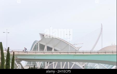 Valencia, Spagna - 04, 05, 2018: Un ragazzo in bicicletta su uno dei ponti che attraversa la Città delle Arti e delle Scienze, con il Principe Felipe Scien Foto Stock