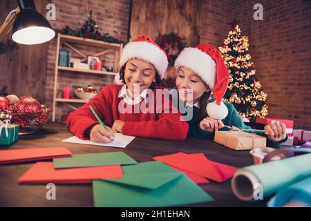 Ritratto di attraenti amici focalizzati allegri preparare l'evento creando festal spirito atmosfera scrivere elenco a casa loft al chiuso Foto Stock