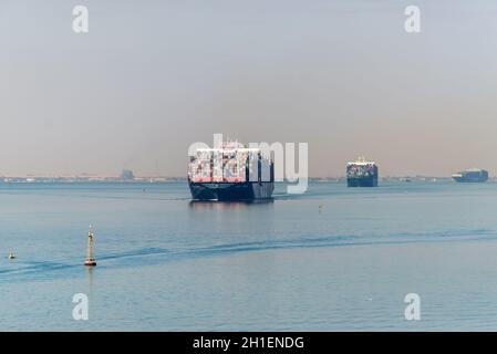 Suez, Egitto - 5 Novembre 2017: Grandi navi portacontainer (navi) passando Canale di Suez in spiaggia sabbiosa di haze (il Grande Lago Amaro) vicino a Suez, Egitto, Africa. Foto Stock