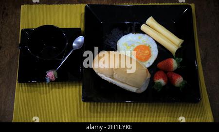 salvador, bahia / brasile - 18 maggio 2020: prima colazione a base di pane, uova fritte, fragole e formaggio. *** Local Caption *** Foto Stock