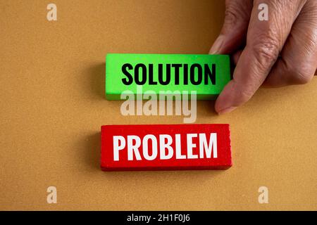 Tenere a mano blocchi di legno con problema e soluzione scritta su di esso. Concetto di risoluzione dei problemi. Foto Stock