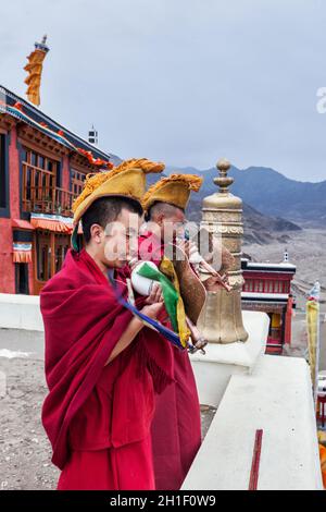 THIKSEY, INDIA - 4 SETTEMBRE 2011: Due monaci buddisti tibetani che soffiano conches durante la mattinata pooja, Thiksey gompa, Ladakh, India Foto Stock