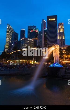 SINGAPORE - 1 GENNAIO 2014: Vista notturna di Singapore Merlion a Marina Bay contro lo skyline di Singapore. Merlion è una famosa icona turistica, mascotte e. Foto Stock