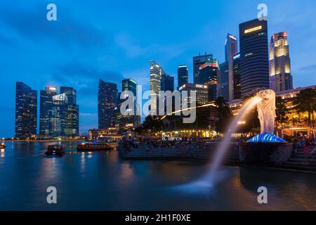 SINGAPORE - 1 GENNAIO 2014: Vista notturna di Singapore Merlion a Marina Bay contro lo skyline di Singapore. Merlion è una famosa icona turistica, mascotte e. Foto Stock