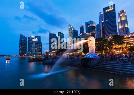 SINGAPORE - 1 GENNAIO 2014: Vista notturna di Singapore Merlion a Marina Bay contro lo skyline di Singapore. Merlion è una famosa icona turistica, mascotte e. Foto Stock