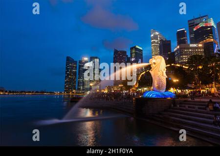 SINGAPORE - 1 GENNAIO 2014: Vista notturna di Singapore Merlion a Marina Bay contro lo skyline di Singapore. Merlion è una famosa icona turistica, mascotte e. Foto Stock