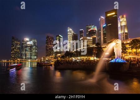 SINGAPORE - 1 GENNAIO 2014: Vista notturna di Singapore Merlion a Marina Bay contro lo skyline di Singapore. Merlion è una famosa icona turistica, mascotte e. Foto Stock
