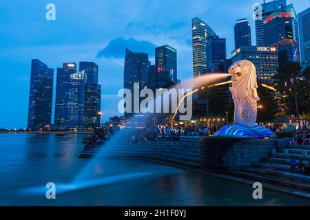 SINGAPORE - 1 GENNAIO 2014: Vista notturna di Singapore Merlion a Marina Bay contro lo skyline di Singapore. Merlion è una famosa icona turistica, mascotte e. Foto Stock