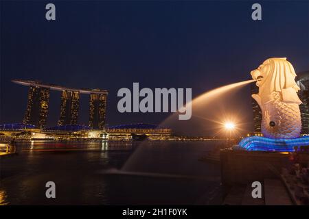 SINGAPORE - 1 GENNAIO 2014: Vista notturna di Singapore Merlion a Marina Bay e Marina Bay Sand Complex. Merlion è una famosa icona turistica, mascotte A. Foto Stock
