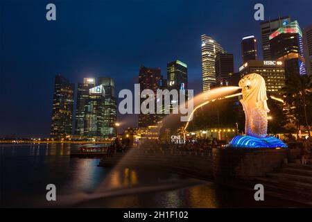 SINGAPORE - 1 GENNAIO 2014: Vista notturna di Singapore Merlion a Marina Bay contro lo skyline di Singapore. Merlion è una famosa icona turistica, mascotte e. Foto Stock