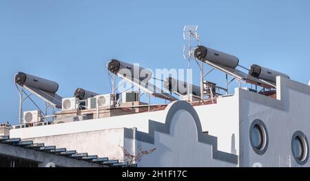 Tavira, Portogallo - 30 aprile 2018: Molti condizionatore d'aria e riscaldamento solare d'acqua sul tetto di una casa in un giorno di primavera Foto Stock