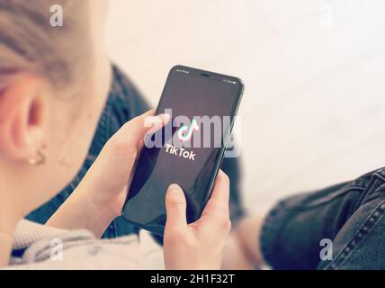 KIEV, UCRAINA-GENNAIO, 2020: Tiktok sullo schermo del telefono intelligente. Young Girl punta o texting Tiktok su smartphone durante un Pandemic Self-Isolation e C. Foto Stock