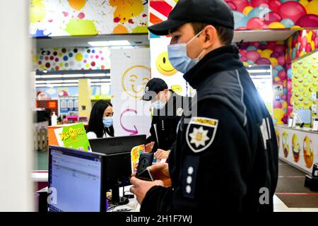 Zaporizhzhia, Ucraina. 18 Ott 2021. ZAPORIZHZHIA, UCRAINA - 18 OTTOBRE 2021 - i funzionari della polizia nazionale dell'Ucraina chiedono ad un amministratore di un complesso di divertimento di produrre il suo certificato di vaccinazione COVID-19 durante un raid congiunto intorno ai centri commerciali con i rappresentanti del servizio statale di alimentazione e consumo, Zaporizhzhia, Ucraina sudorientale credito: Ukrinform/Alamy Live News Foto Stock