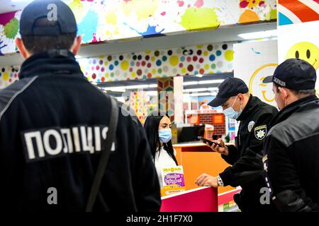 Zaporizhzhia, Ucraina. 18 Ott 2021. ZAPORIZHZHIA, UCRAINA - 18 OTTOBRE 2021 - un ufficiale della polizia nazionale dell'Ucraina controlla un certificato di vaccinazione COVID-19 di un amministratore in un complesso di divertimento durante un raid congiunto intorno ai centri commerciali con i rappresentanti del servizio alimentare e del consumatore di Stato, Zaporizhzhia, Ucraina sudorientale credito: Ukrinform/Alamy Live News Foto Stock