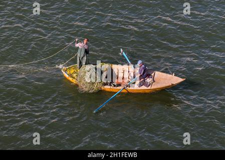 Ismailia, Egitto - 5 Novembre 2017: i pescatori in barca di legno di catturare pesci net sul nuovo canale di Suez, Ismailia, Egitto, Africa. Foto Stock