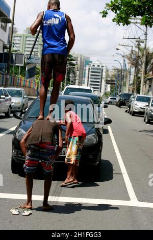 salvador, bahia / brasile - 24 dicembre 2014: Il bambino è visto chiedendo donazioni nel mezzo del traffico di veicoli nel quartiere Pituba di Salvado Foto Stock