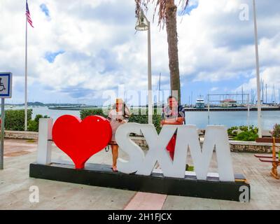 Marigot, Sint Maarten - 14 maggio 2016: La coppia in posa vicino a segno e statua amo San Martino a Marigot, isola di St.Maarten Foto Stock