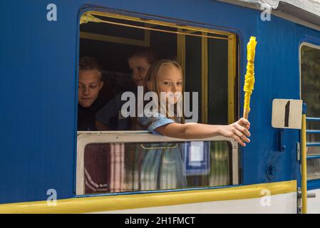 Kiev, Ucraina - 3 Agosto 2013: il conduttore ragazza dà un segnale per la partenza dei carri dei figli di ferrovia a Kiev (Kiev), l'Ucraina. Foto Stock