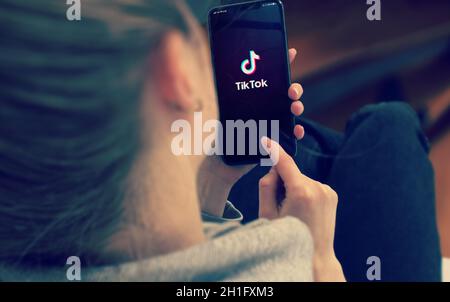 KIEV, UCRAINA-GENNAIO 2020: Tiktok sullo schermo dello smartphone. Telefono mobile di puntamento o texting della ragazza giovane durante un autoisolamento pandemico e Coronaviru Foto Stock