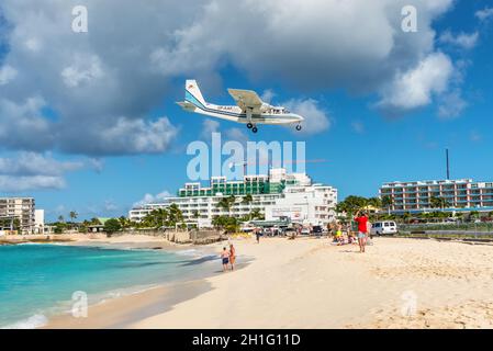 Simpson Bay, Saint Maarten - 17 dicembre 2018: la BN Britten-Norman-2B-21 Islander aereo sorvola beachgoers in Saint Martin, Antille olandesi, auto Foto Stock