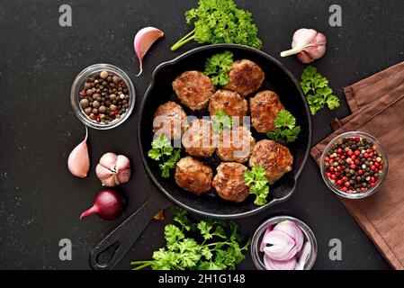 Gustose cotolette fatte in casa di carne macinata in padella su sfondo nero. Vista dall'alto, piatto Foto Stock