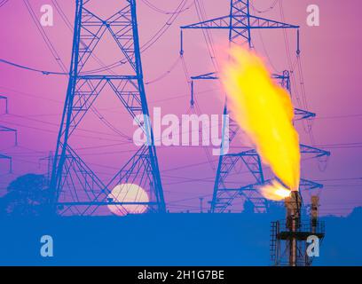 Piloni elettrici all'alba con camino a gas per impianti industriali/chimici. REGNO UNITO. Gas crescente, elettricità, energia.., prezzi, riscaldamento globale, concetto Foto Stock
