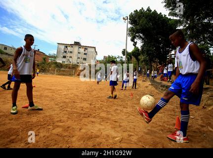 salvador, bahia / brasile - 21 dicembre 2015: I giovani si vedono giocare a sport sul campo di calcio a terra nel quartiere Fazenda Grande in Foto Stock