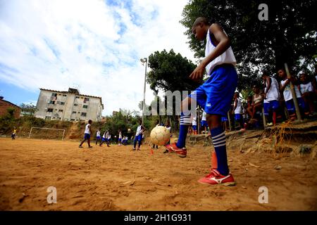 salvador, bahia / brasile - 21 dicembre 2015: I giovani si vedono giocare a sport sul campo di calcio a terra nel quartiere Fazenda Grande in Foto Stock