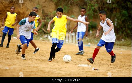 salvador, bahia / brasile - 21 dicembre 2015: I giovani si vedono giocare a sport sul campo di calcio a terra nel quartiere Fazenda Grande in Foto Stock