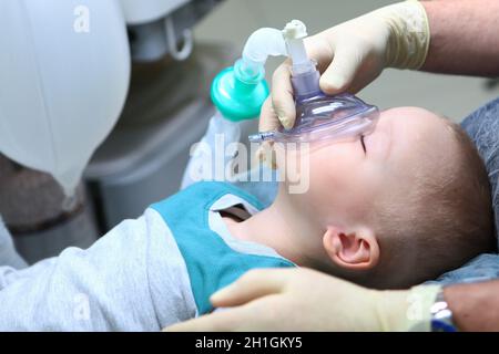 Il bambino è sotto anestesia generale. Trattamento dei denti del bambino.il dispositivo di ventilazione artificiale dei polmoni.spazio di copia. Foto Stock