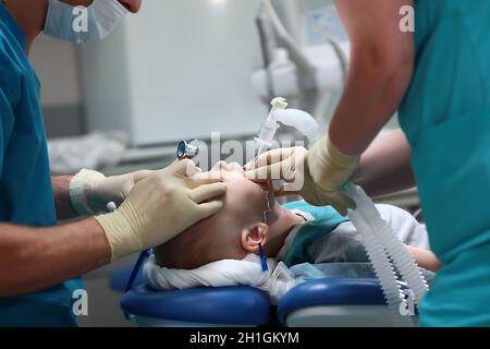 Un anestesista inserisce un tubo respiratorio nella trachea di un bambino. Funzionamento in anestesia generale. Il dispositivo di ventilazione artificiale Foto Stock
