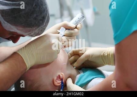 Un anestesista inserisce un tubo respiratorio nella trachea di un bambino. Funzionamento in anestesia generale. Spazio di copia. Foto Stock