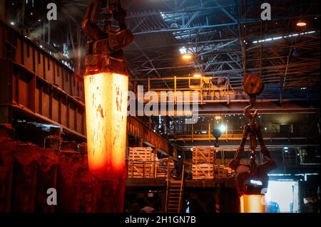 Il getto di metallo rosso-caldo viene trasportato da una gru metallurgica Foto Stock