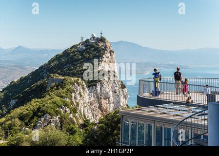 Gibilterra, Regno Unito - 18 Maggio 2017: turisti e macachi sulla piattaforma di osservazione con il Rock e la fascia costiera spagnola alla parte posteriore, Gibilterra, Regno Foto Stock